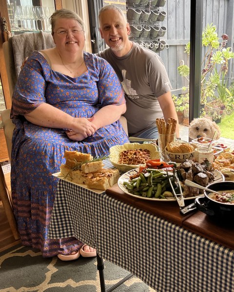 Krissy and Tim behind a table of food Krissy made